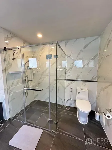 独立式住宅 出租在Bang Phli, Samut Prakan - 现代卫浴，仿石材墙面、玻璃干湿分离淋浴间与坐便器。