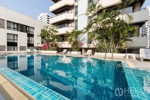 คอนโด ให้เช่าในKhlong Toei, Bangkok - สระว่ายน้ำกลางแจ้งของคอนโด มีเก้าอี้อาบแดดและต้นปาล์ม