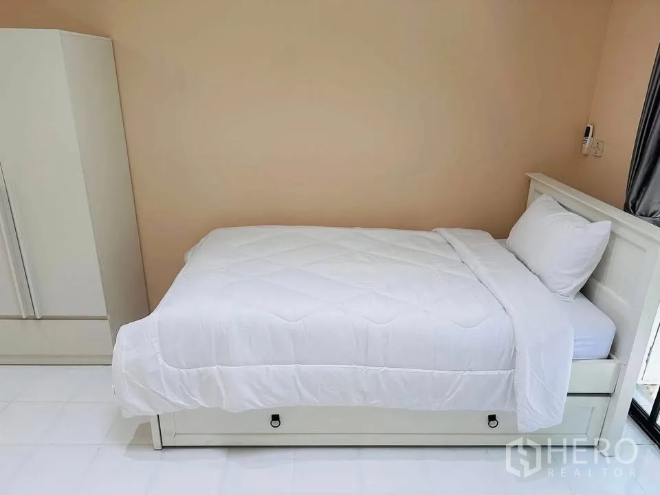 联排别墅 for rent - 小卧室配白色单人床与衣柜，墙面中性色。