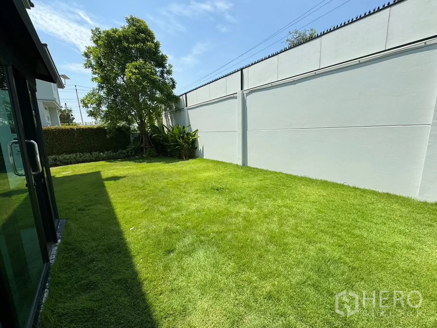 独栋房屋 for rent in Prawet, Bangkok - 私家庭院草坪向阳，设树木与高围墙。