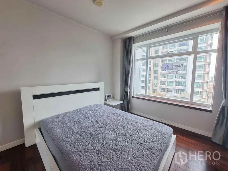 公寓 出租在Ratchathewi, Bangkok - 采光良好的卧室，大飘窗与灰色窗帘，可见城市景观。