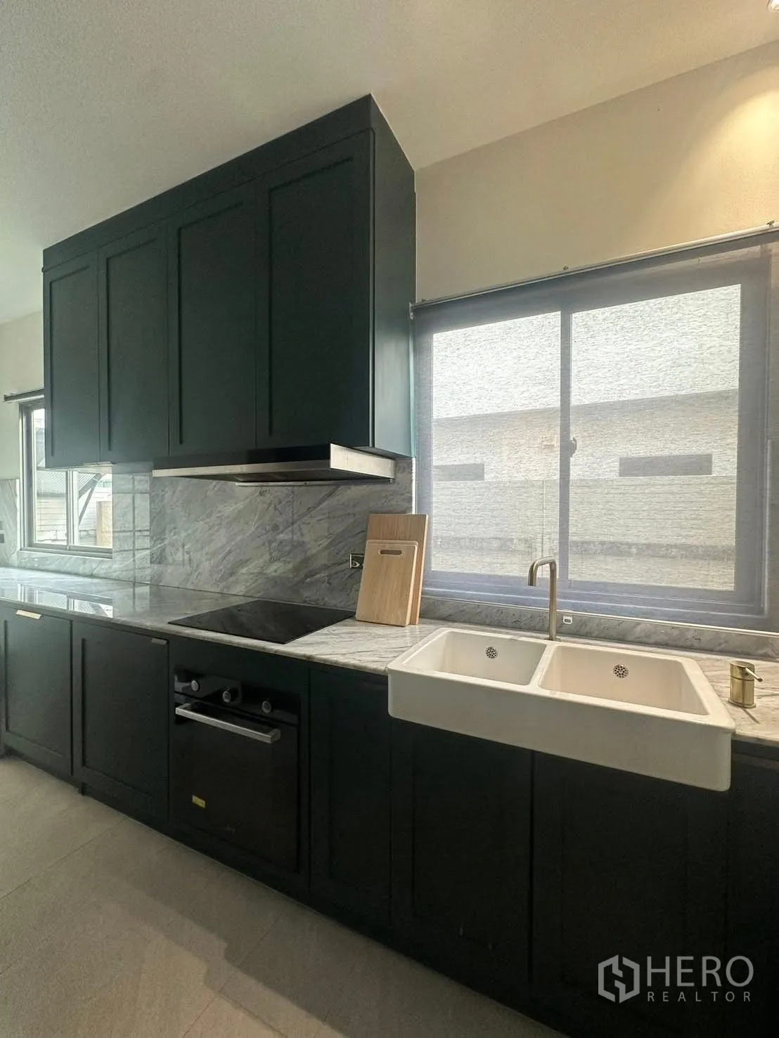 บ้าน ให้เช่าในLat Krabang, Bangkok - ครัวสมัยใหม่ ตู้สีเข้ม เคาน์เตอร์หินอ่อน เตาและอ่างล้างจานคู่