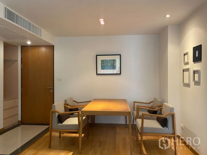 คอนโด ให้เช่าหรือขายในKhlong Toei, Bangkok - มุมรับประทานอาหารสไตล์มินิมอล โต๊ะไม้และเก้าอี้บุนวมสี่ที่นั่ง ใต้แสงไฟอบอุ่น