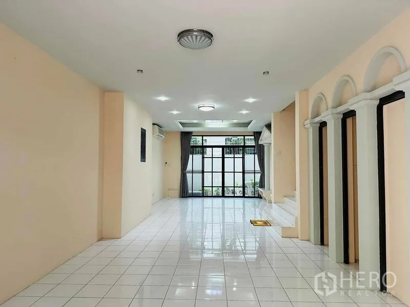 Home Office for rent - Long open-plan hall with arched details, tiled floor and full-height glass doors.