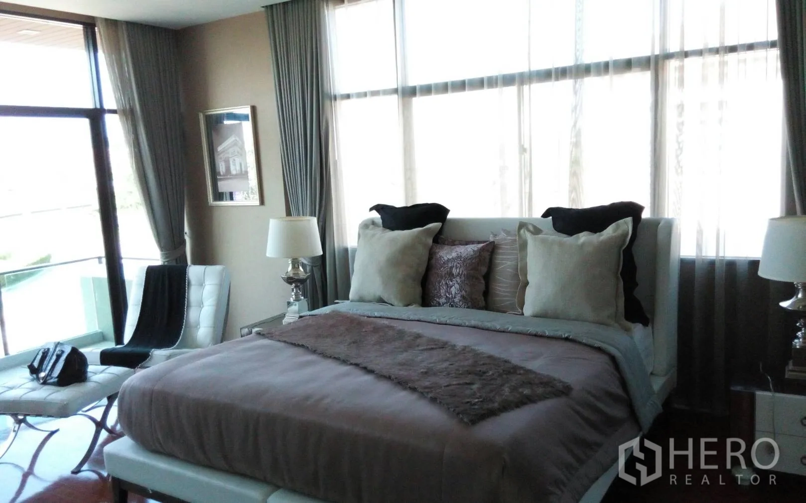 Detached House for rent or sale in Prawet, Bangkok - Second bedroom with large windows, queen bed and seating area.