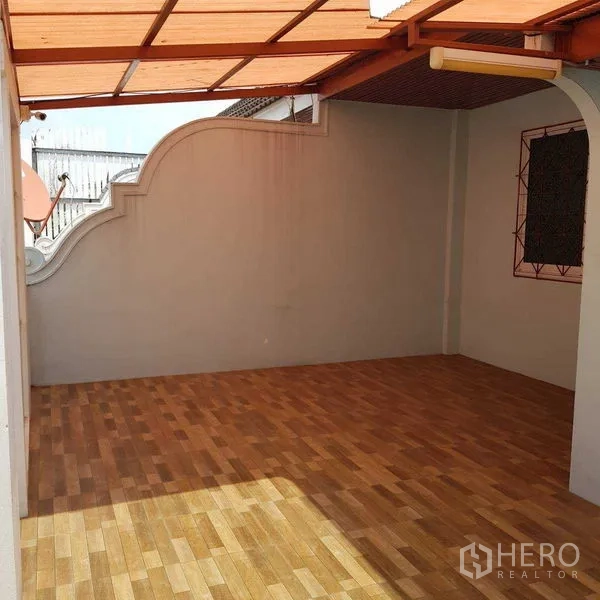 Home Office for rent in Watthana, Bangkok - Covered rooftop terrace with wood-look tiles and curved wall detail.