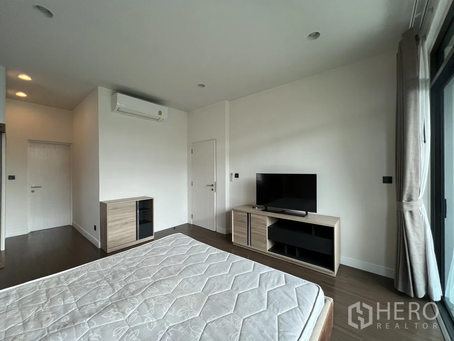 บ้าน ให้เช่าในBang Kapi, Bangkok - ห้องนอนใหญ่พร้อมชั้นวางทีวี และหน้าต่างกว้าง