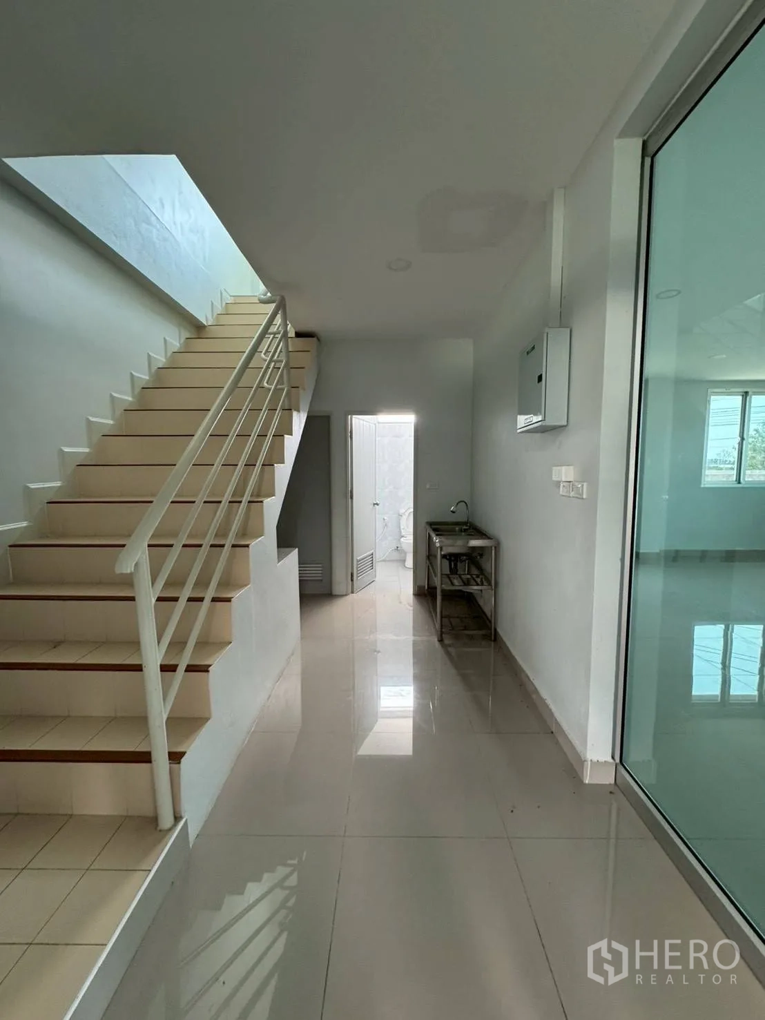 Warehouse for rent in Phutthamonthon, Nakhon Pathom - Hallway with staircase, glass partition door and access to a restroom on the ground floor.