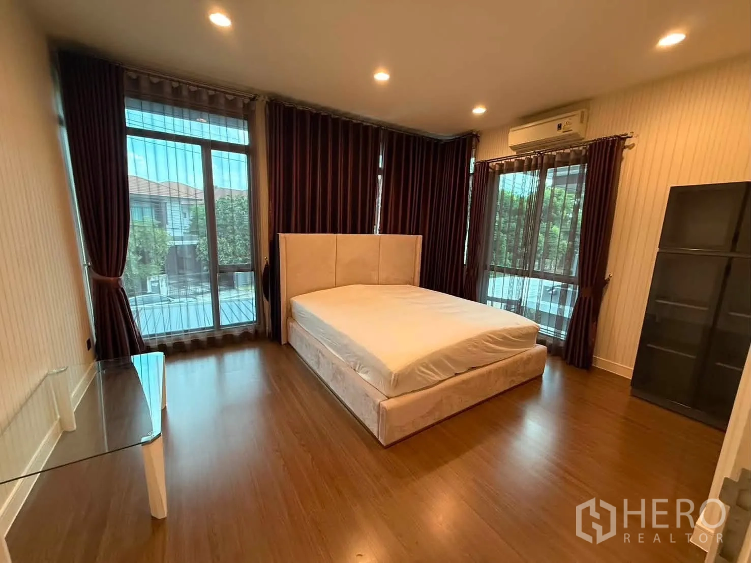 独栋房屋 for rent in Bang Kapi, Bangkok - 主卧转角大窗，两侧落地玻璃与深色窗帘。