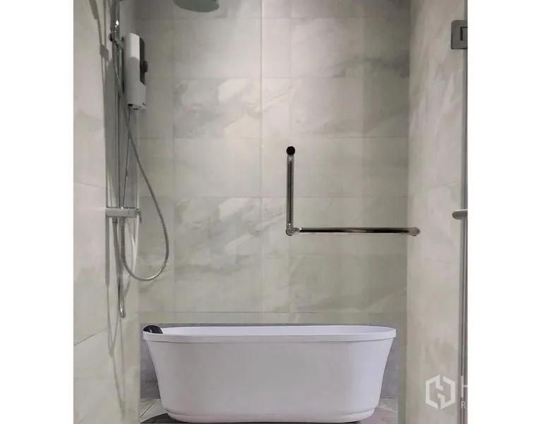 Condominium for rent in Watthana, Bangkok - Bathroom with freestanding soaking tub and handheld shower on marble tiles.
