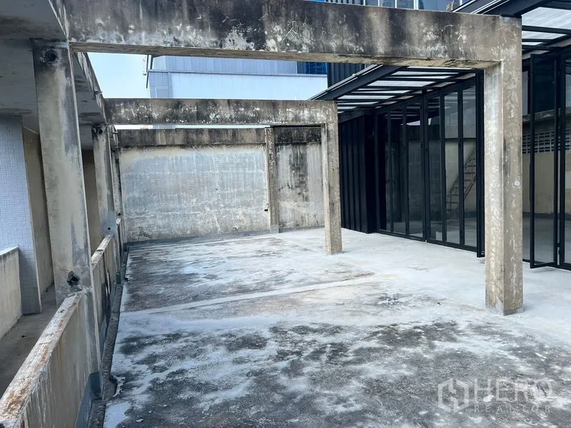 零售空间 出租在Watthana, Bangkok - 屋顶露台，风化混凝土地坪与结构梁，玻璃立面相连