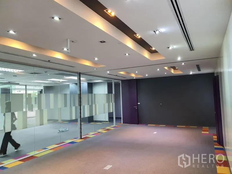 Office Space for rent in Watthana, Bangkok - Meeting room with a glass wall, spotlights, and a dark accent wall.