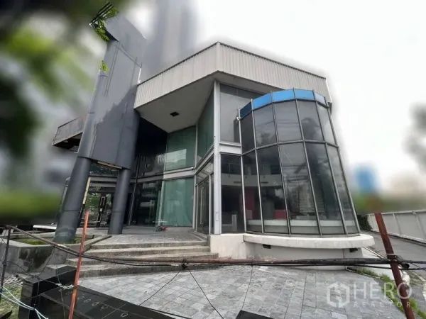 零售空间 出租 - 建筑转角带圆弧玻璃舱体，临街展示窗与入口台阶