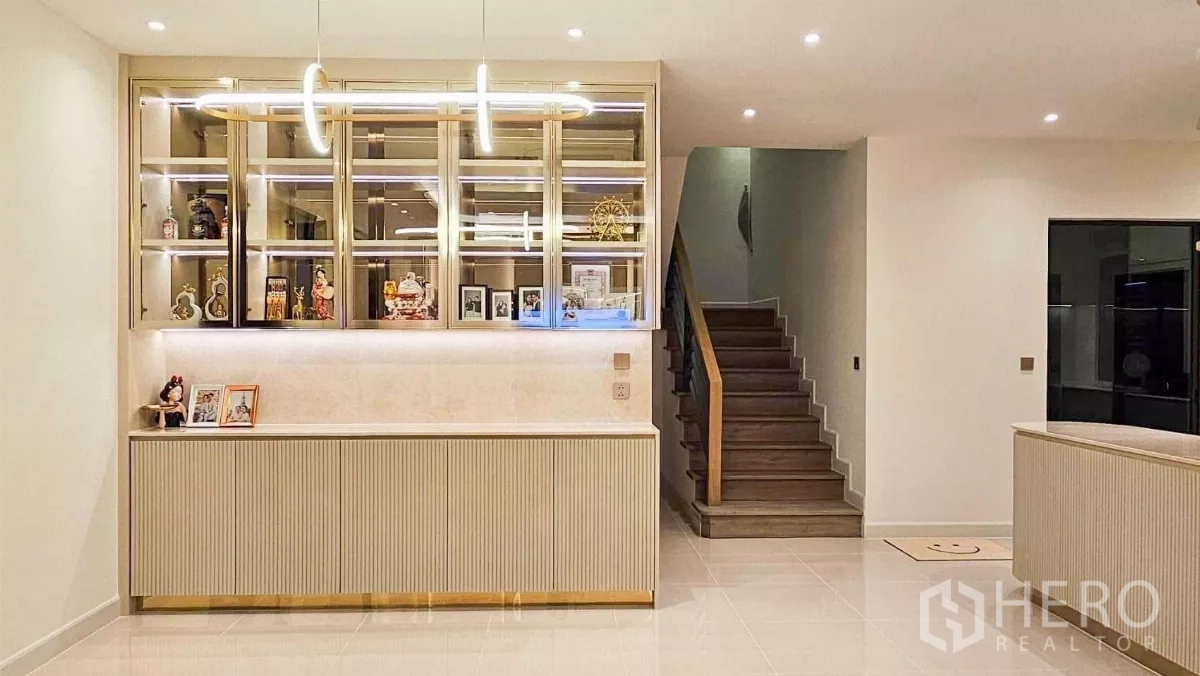 บ้าน ให้เช่าหรือขายในPrawet, Bangkok - โถงทางเข้าพร้อมตู้โชว์ไฟในตัว โคมแขวน และบันไดไม้ขึ้นชั้นสอง