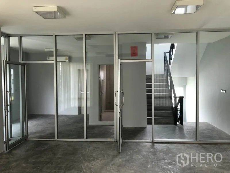 Home Office for rent in Wang Thonglang, Bangkok - Full-height glass partitions forming meeting rooms beside the stairwell.