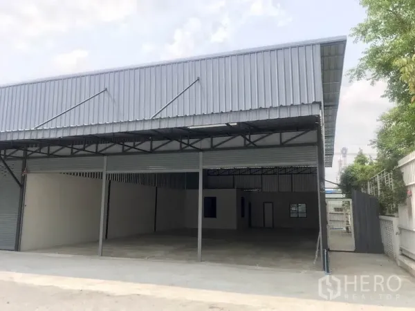 คลังสินค้า ให้เช่าในPathum Thani - ด้านหน้าโกดังเมทัลชีท ประตูม้วน พร้อมพื้นที่โหลดสินค้ากันแดดฝน.