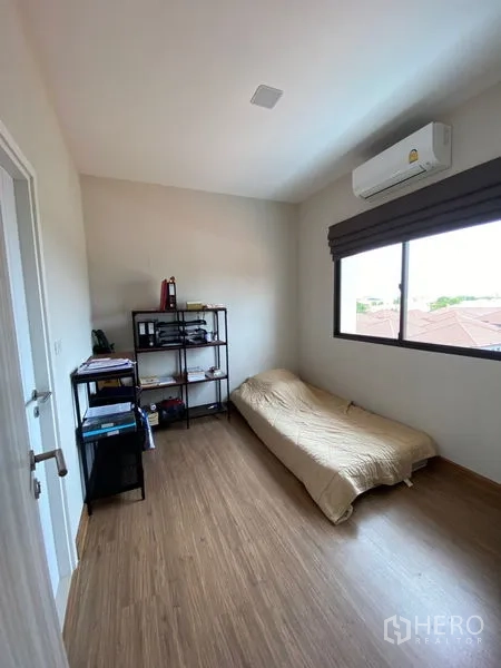 ทาวน์เฮาส์ ให้เช่าในSuan Luang, Bangkok - ห้องนอนรับแขก เตียงเดี่ยว ชั้นวางของ และเครื่องปรับอากาศหน้าต่าง