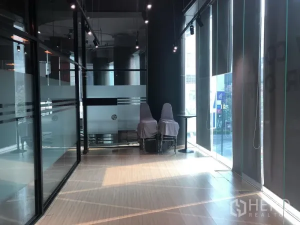 Office Space for rent in Khlong Toei, Bangkok - Bright serviced office interior with floor-to-ceiling windows, glass partitions, track lighting and light wood flooring in Phra Khanong.