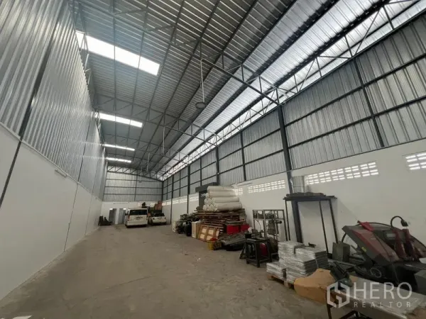 货栈 出租在Khlong Sam Wa, Bangkok - 仓库内部宽敞通透，钢桁架屋顶与采光天窗，混凝土地面，设有存储区。