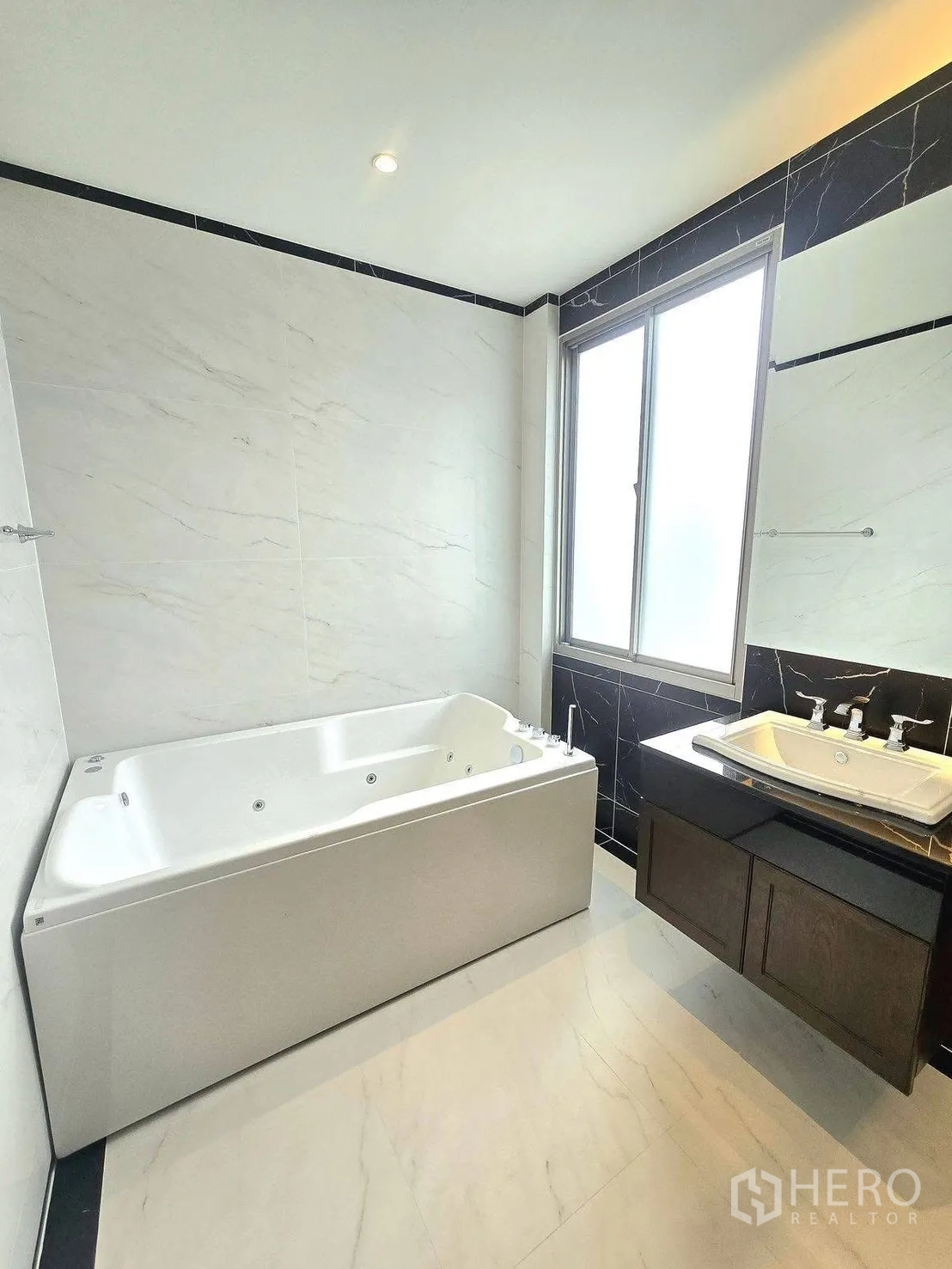 Detached House for rent or sale in Bang Phli, Samut Prakan - Bright luxury bathroom with a large jacuzzi bathtub, marble-style walls, vanity and frosted window.