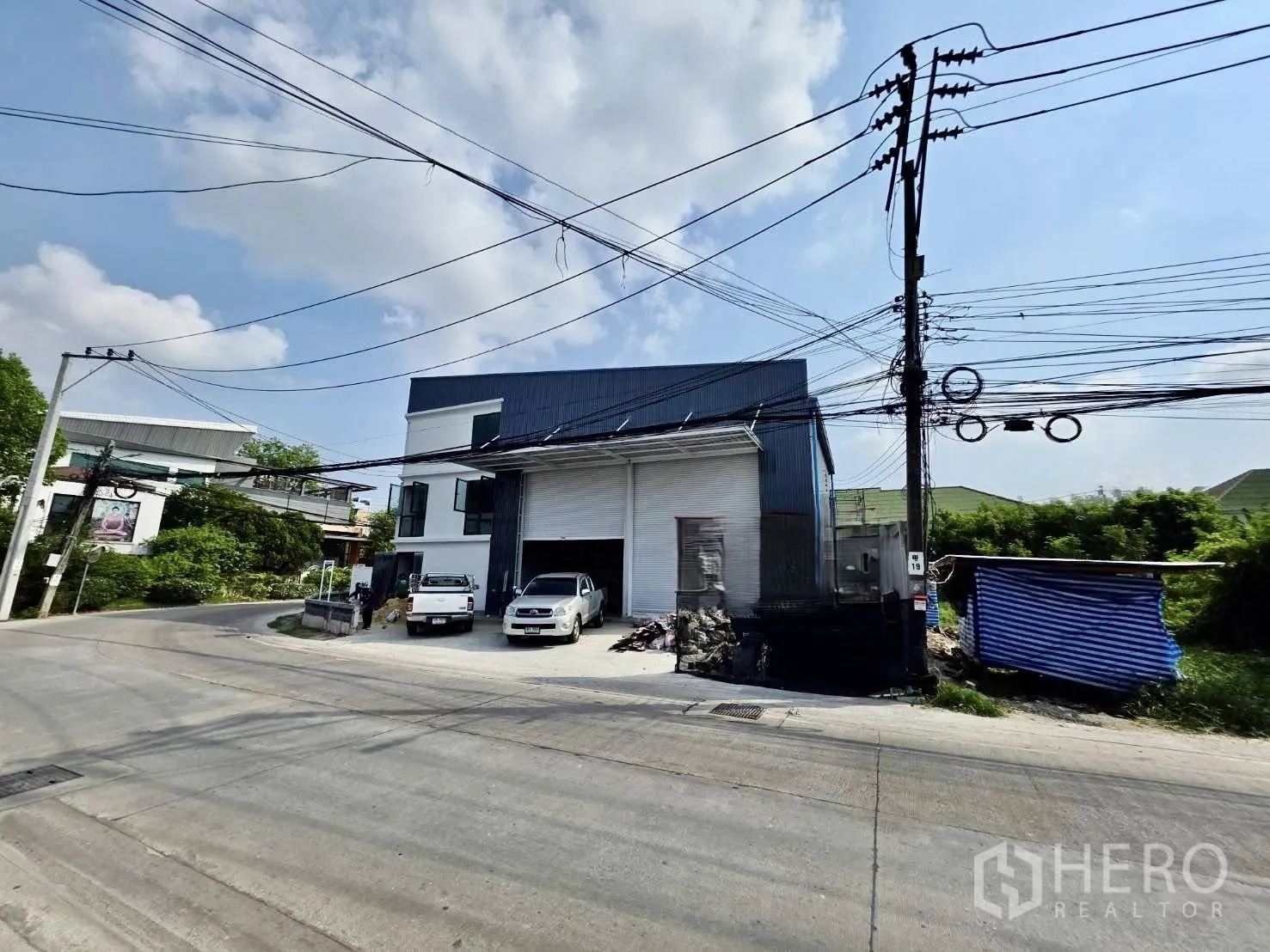 โกดัง for rent or sale in Mueang Nonthaburi, Nonthaburi - มุมมองริมถนนของโกดังสมัยใหม่ในบางรักน้อย พร้อมประตูม้วนคู่ ลานจอดรถและทางเข้าในนนทบุรี