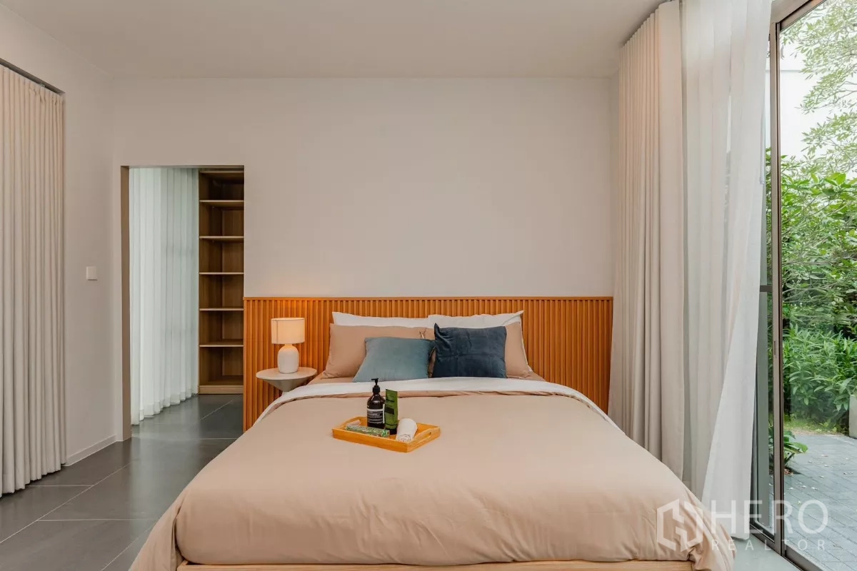 บ้าน ให้เช่าในSaphan Sung, Bangkok - ห้องนอนอบอุ่น หัวเตียงไม้ และทางเข้าห้องแต่งตัว