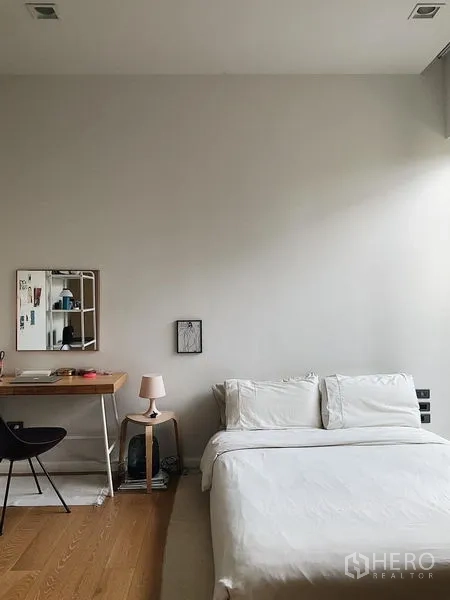 Detached House for sale in Bang Kapi, Bangkok - Bedroom with study desk, white bedding, and high ceiling.