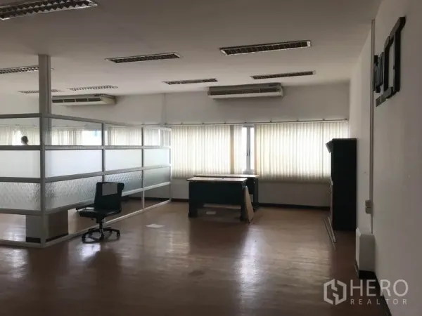 Office Space for rent in Khlong Toei, Bangkok - Open office space with desks, frosted glass partitions, long windows with blinds, and overhead fluorescent lights.