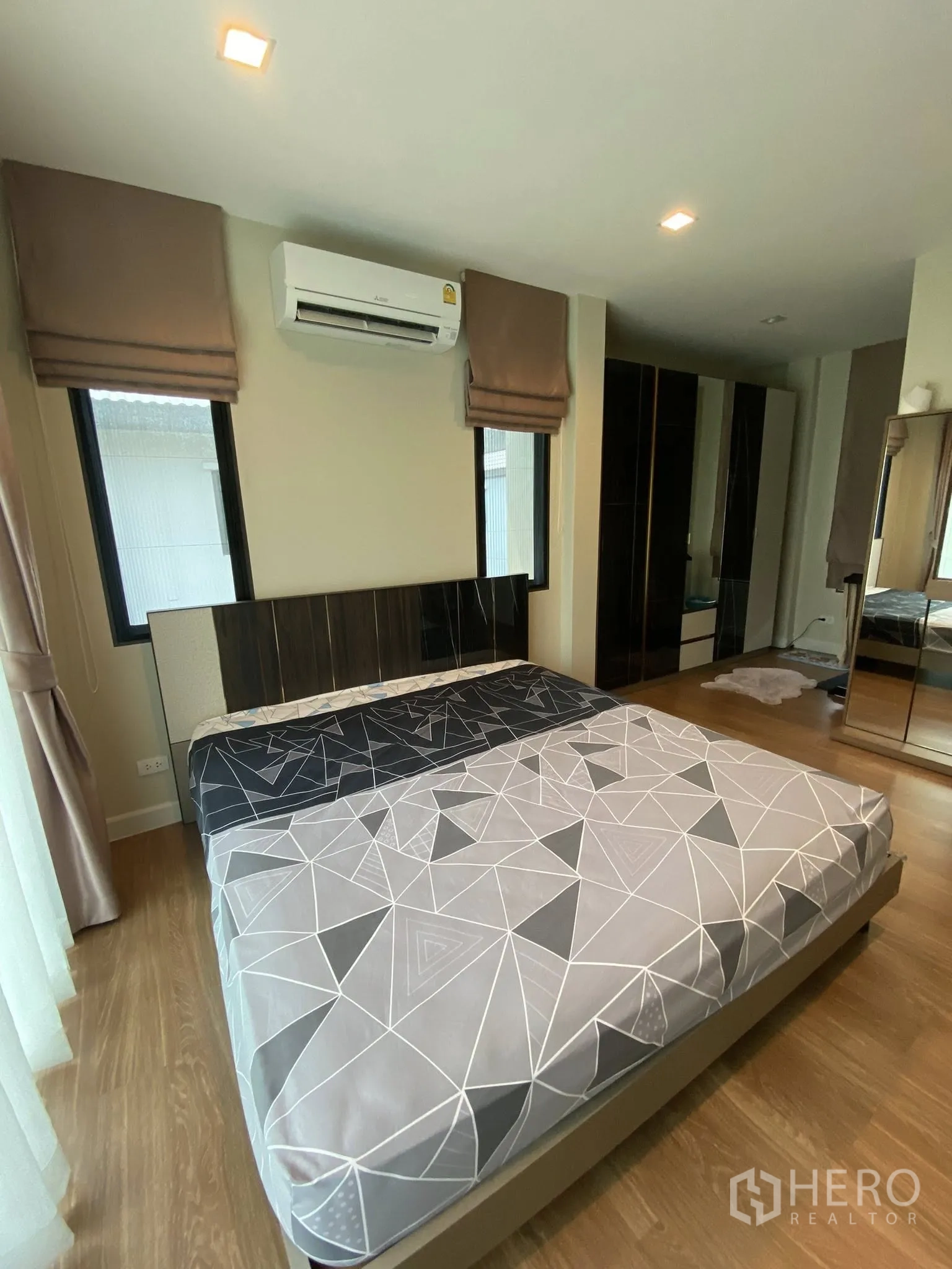 Detached House for sale in Saphan Sung, Bangkok - Bedroom angle showing bed, split-type air conditioner, and wardrobes.