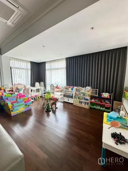 Detached House for sale - Bright playroom with floor-to-ceiling windows, dark curtains and organized toy storage.