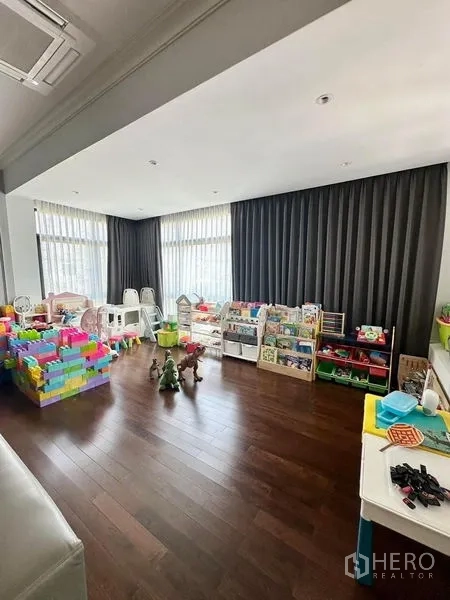 Detached House for sale - Bright playroom with floor-to-ceiling windows, dark curtains and organized toy storage.