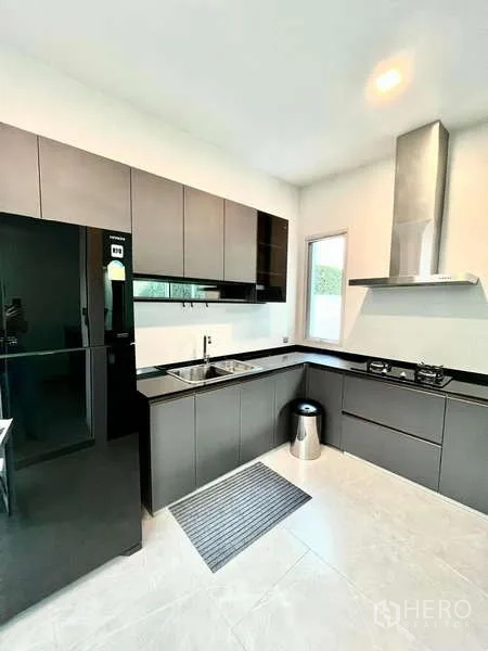 独立式住宅 出租或出售在Bang Phli, Samut Prakan - 时尚U形厨房，现代橱柜、燃气灶与抽油烟机。