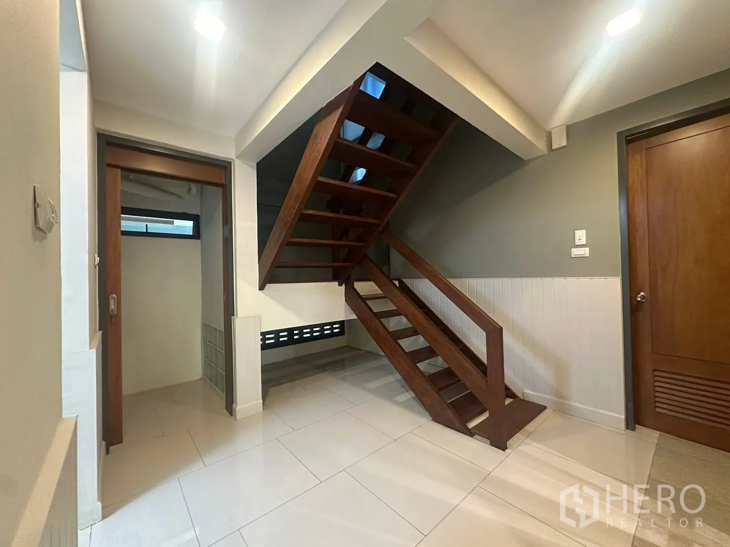 บ้าน for rent in Watthana, Bangkok - โถงบันไดไม้แบบขั้นโปร่ง พื้นกระเบื้องสีขาวเงา