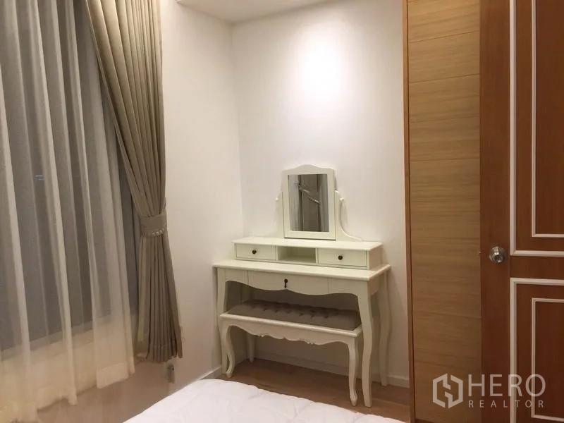 公寓 出租在Sathon, Bangkok - 卧室角落的复古梳妆台与衣柜，米色系装饰。