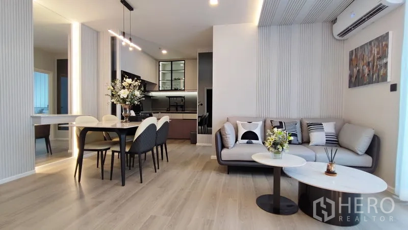 Condominium for rent in Bang Kho Laem, Bangkok - Living room with sofa and nesting coffee tables opening to the kitchen area.