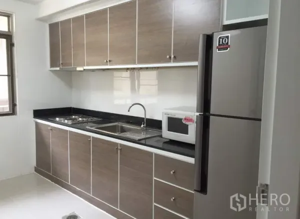 คอนโด ให้เช่าหรือขายในWatthana, Bangkok - ครัวแบบแกลลีย์ ตู้ลายไม้ เคาน์เตอร์หินสีดำ อ่างล้างคู่ เตาไมโครเวฟ และตู้เย็นขนาดใหญ่