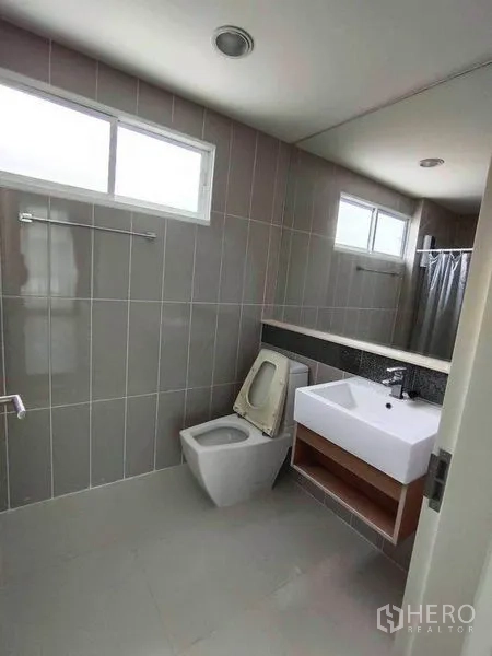 联排别墅 出租在Wang Thonglang, Bangkok - 现代灰色瓷砖浴室，带洗手台、坐便器与淋浴区。