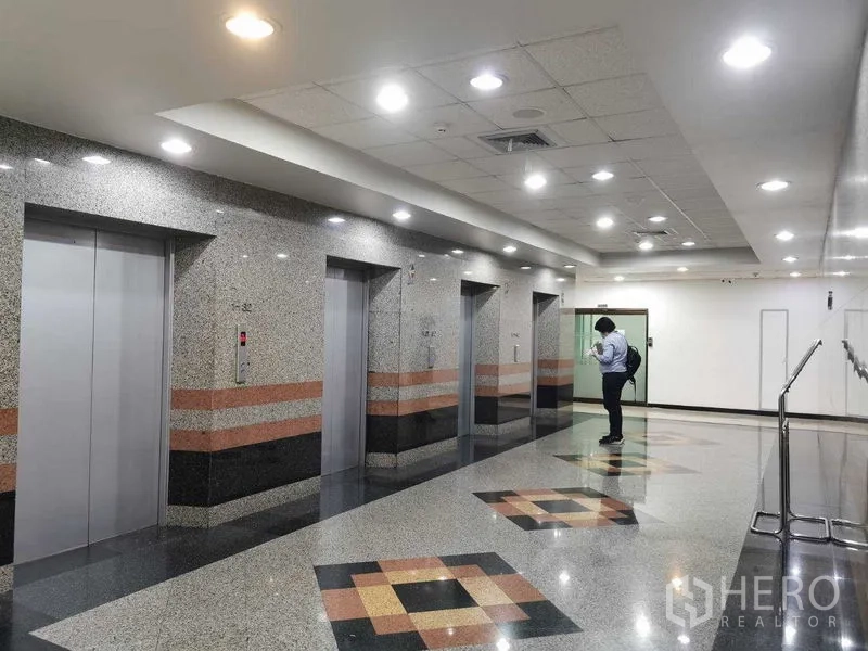 Office Space for rent in Watthana, Bangkok - Modern elevator lobby with multiple lifts and polished granite finishes.