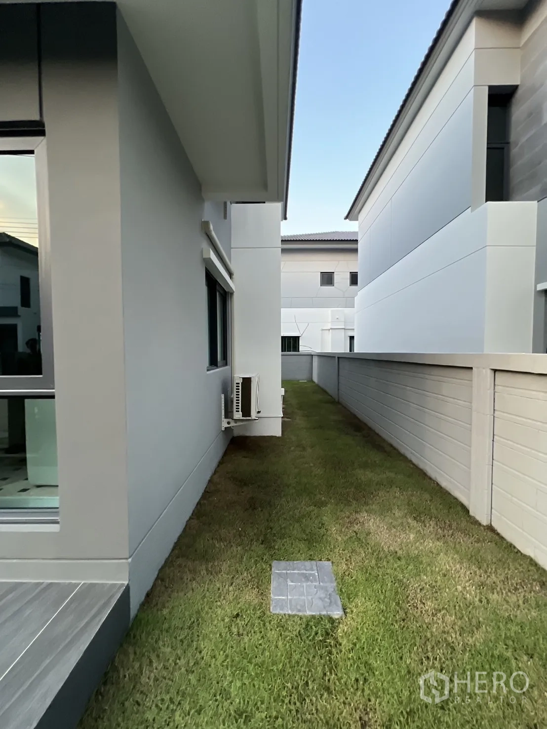 บ้าน ให้เช่าในBang Phli, Samut Prakan - ด้านข้างบ้านมีสนามหญ้าแคบยาวและกำแพงส่วนตัว