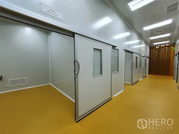 Factory for sale in Lam Luk Ka, Pathum Thani - Another view of the cleanroom corridor with multiple rooms and clear strip curtains at the end.