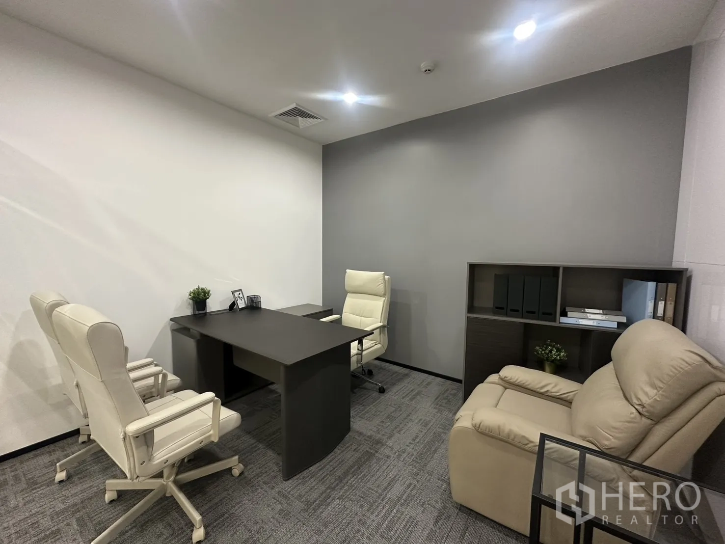 办公室 for rent in Pathum Wan, Bangkok - 小型会议室，深色桌、白色座椅与米色躺椅。