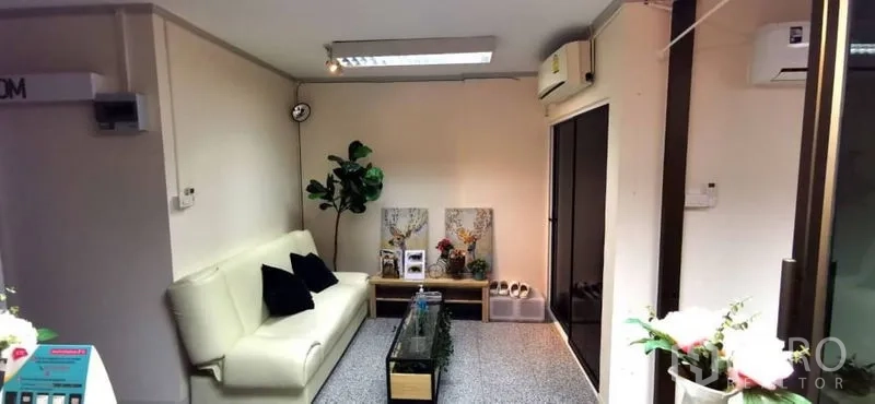 Home Office for rent in Khlong Toei, Bangkok - Cozy reception lounge featuring a cream sofa, glass coffee table, indoor plant, and air-conditioning.