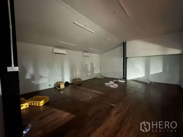 货栈 出租 - 二层办公室，木纹地板、分体空调与长条照明。