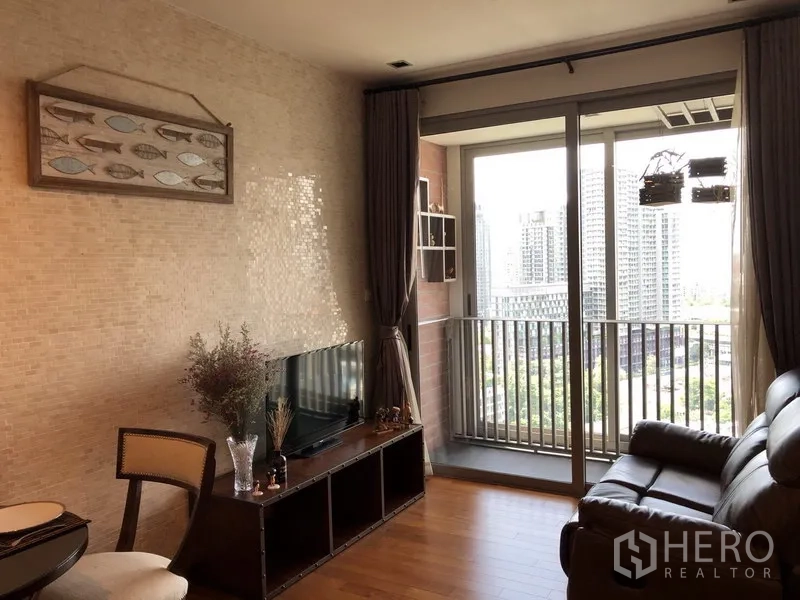 คอนโด ให้เช่าในKhlong Toei, Bangkok - ห้องนั่งเล่นสว่างพร้อมโซฟาหนัง ชั้นวางทีวี และประตูกระจกบานเลื่อนออกสู่ระเบียงวิวเมือง