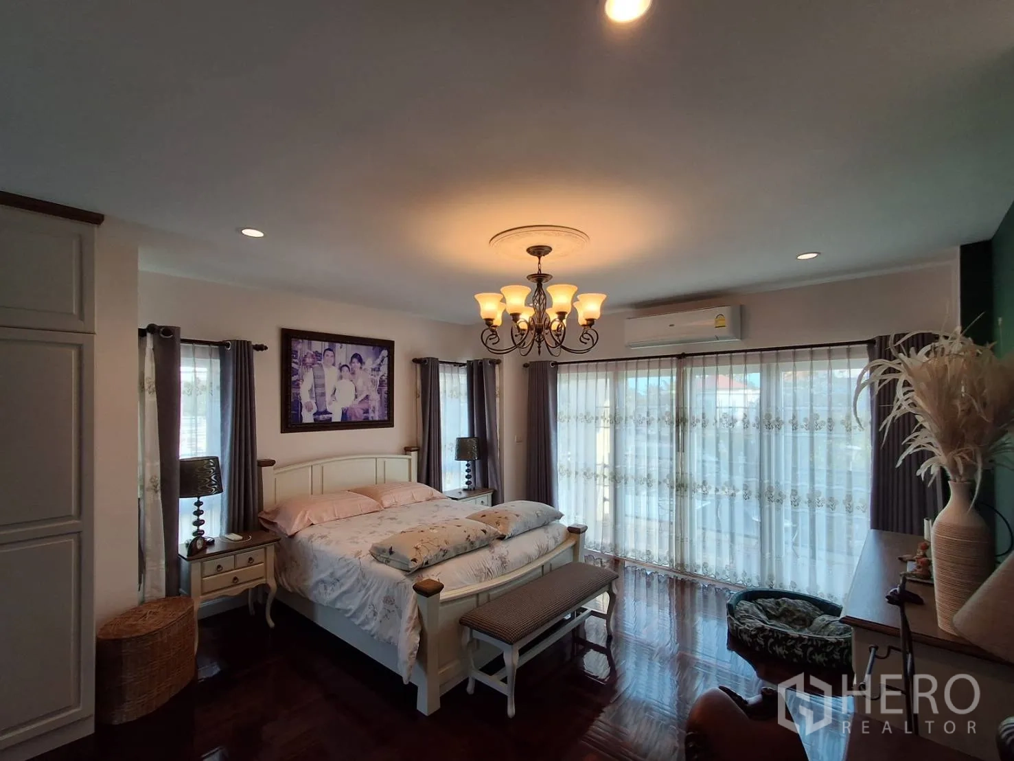 Detached House for rent or sale in Ban Chang, Rayong - Bright master bedroom with balcony doors, bedside tables and curtains.