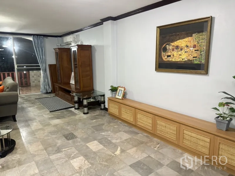 联排别墅 出租在Prawet, Bangkok - 狭长客厅通向阳台，配窗帘与自然采光。