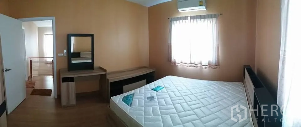Detached House for rent in Pathum Thani - Second bedroom with dressing table, built-in headboard, wood floors and natural light