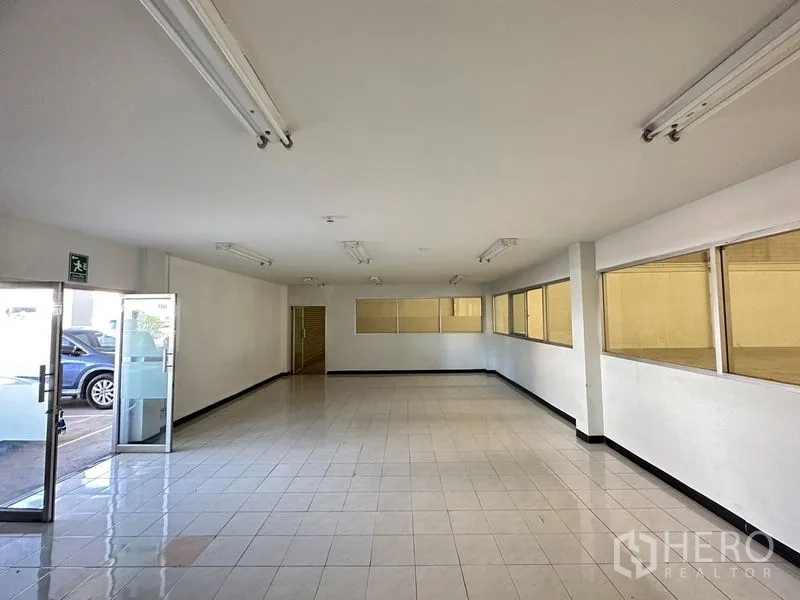 Factory for rent in Si Racha, Chon Buri - Ground-floor office space with windows facing the warehouse and glass entry door.