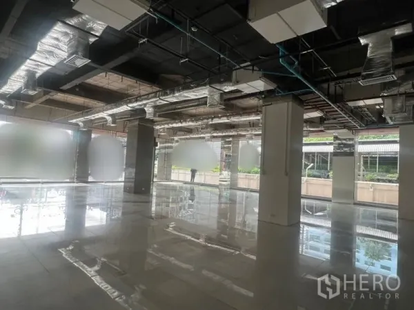 零售空间 出租 - 开放式零售室内空间，抛光地砖、落地窗与外露风管。