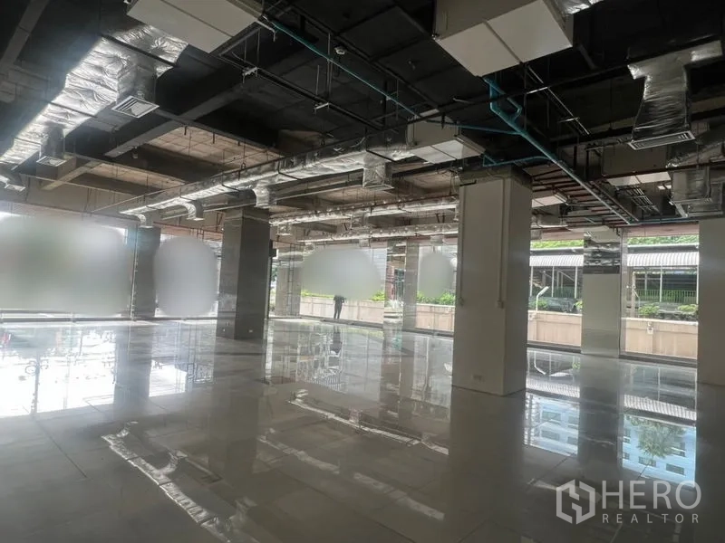 零售空间 出租 - 开放式零售室内空间，抛光地砖、落地窗与外露风管。